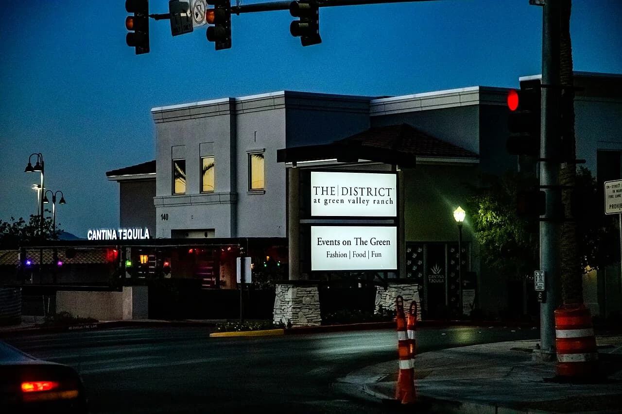 Illuminated entrance sign for The District at Green Valley Ranch at twilight