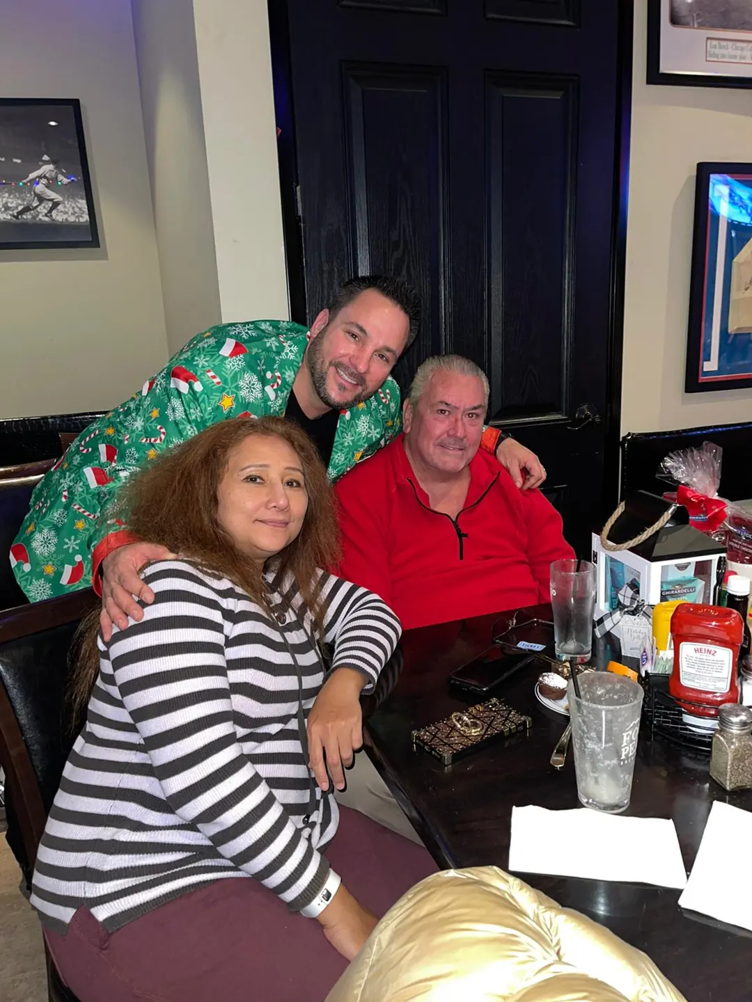 Three guests smile together at the 2022 Christmas party.