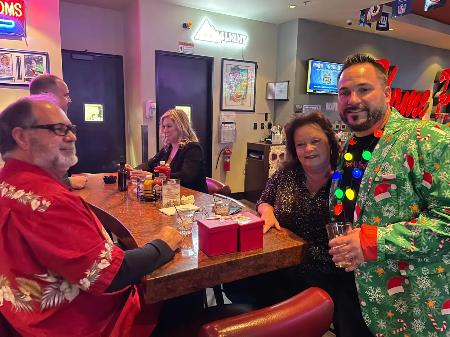 Guests in festive sweaters share a moment at the holiday gathering.